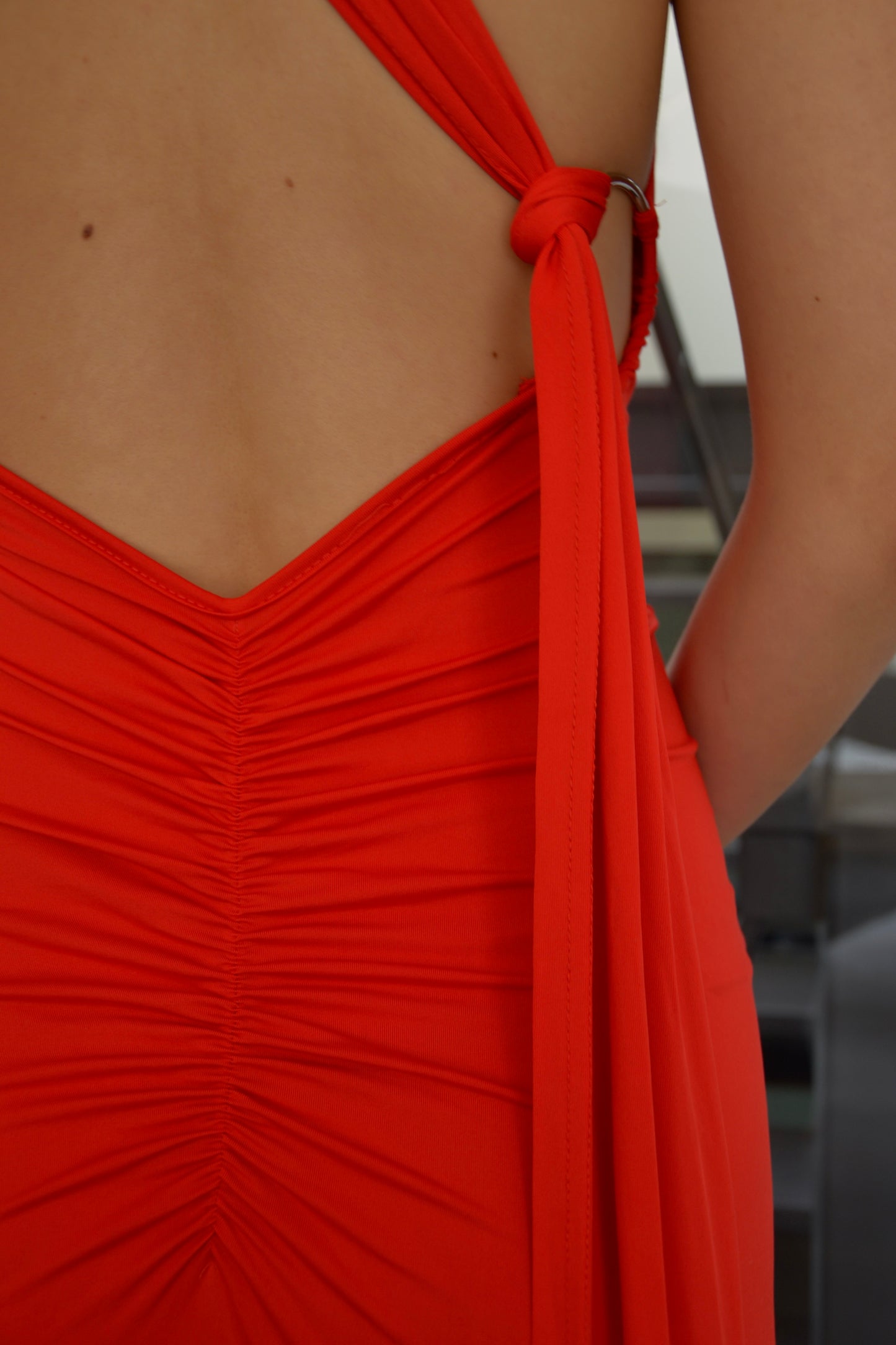 Close-up van de open rug van de Red Ring Dress, avondjurk via jurken huren service van Pineloue.