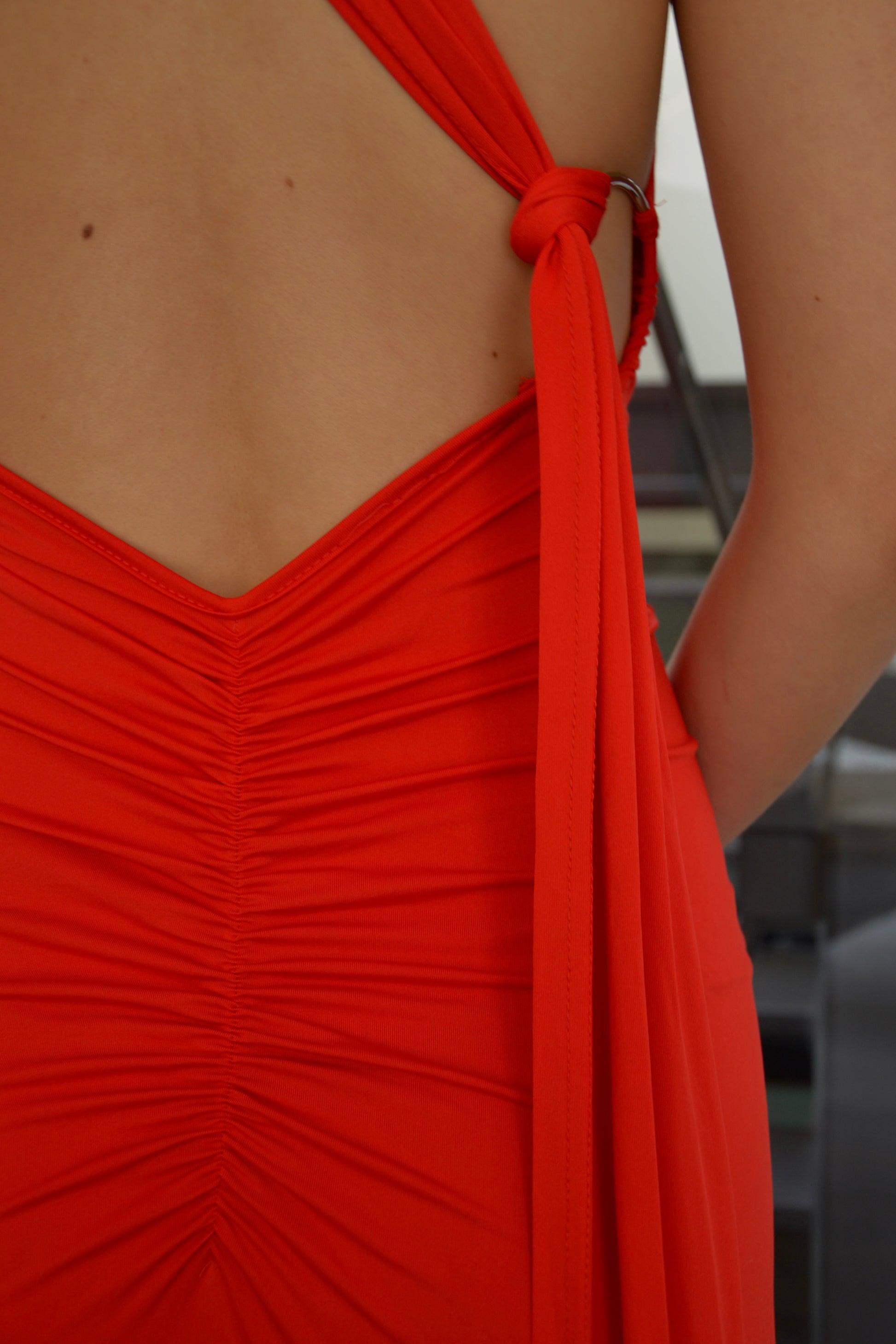 Close-up van de open rug van de Red Ring Dress, avondjurk via jurken huren service van Pineloue.